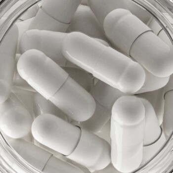 Zoomed in view of glass bottles with capsules in it from the overhead view looking down onto bottle.