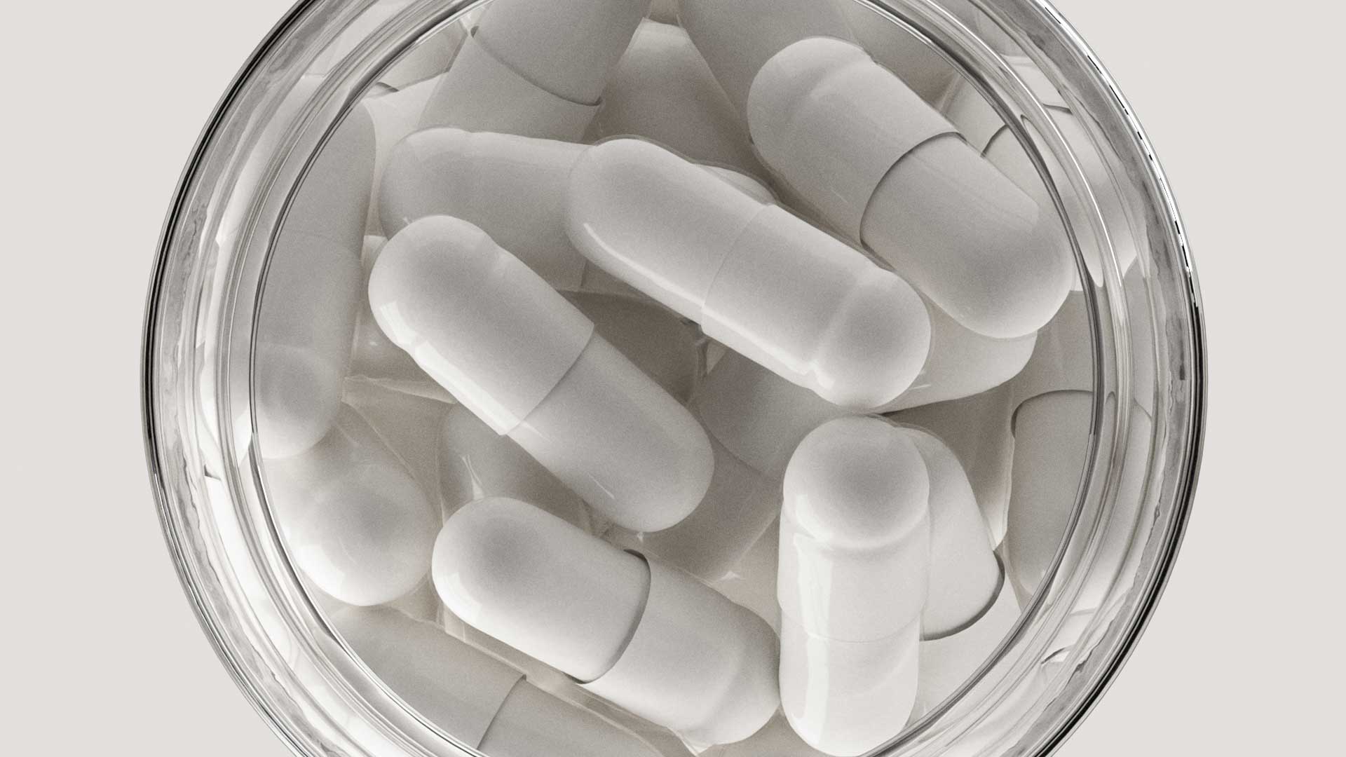 Zoomed in view of glass bottles with capsules in it from the overhead view looking down onto bottle.