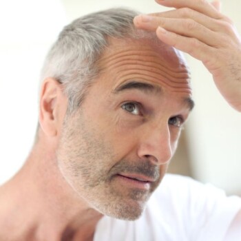 Older man examining his thinning hair.