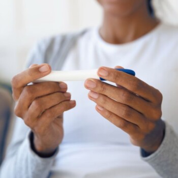 A person holding a pregnancy test.