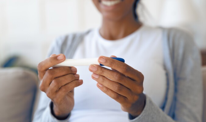 A woman holding a pregnancy test.