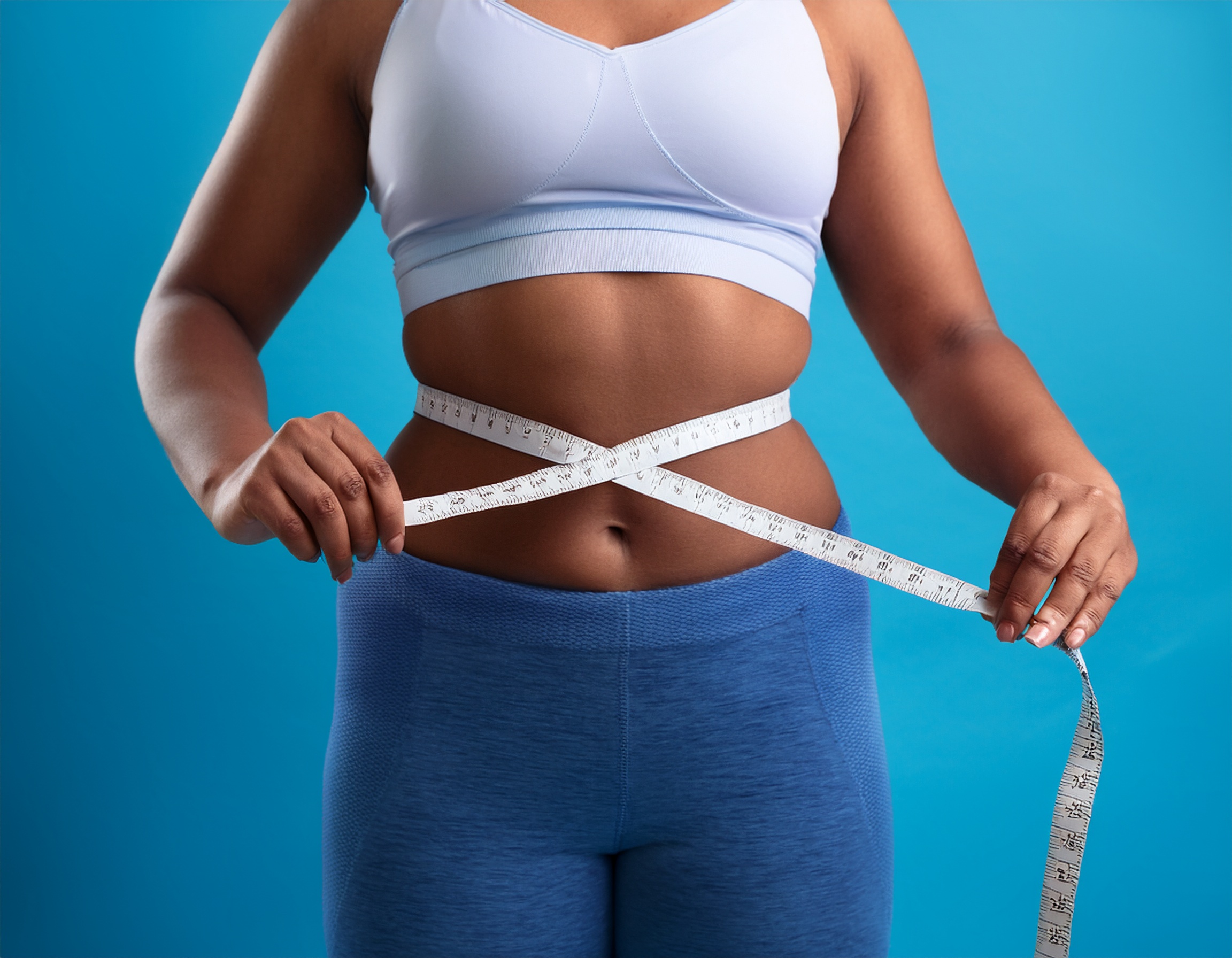 woman holding a tape measure around her waist